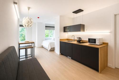 a kitchen with a sink and a microwave in a room at Nova MSuites Valencia in Valencia