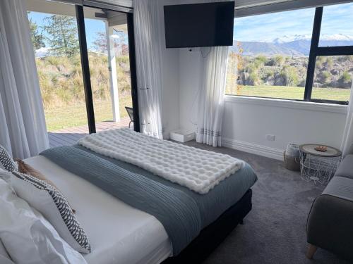 a bedroom with a bed and a large window at Guesthouse B in Twizel