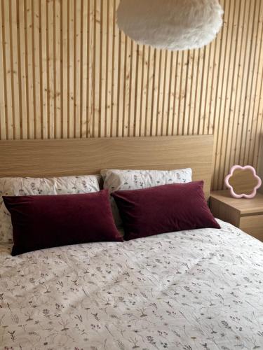 a bedroom with a bed with two red pillows at Malūno namai 2 in Palanga