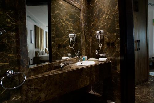 a bathroom with a sink and a large mirror at Alammariah Hills Resort- Riyadh in Diriyah