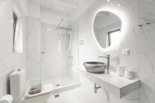 a white bathroom with a sink and a mirror at Lambda Luxury Villa 1 in Syvota