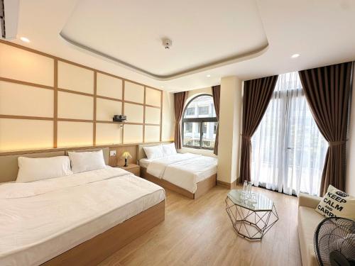 a hotel room with two beds and a couch at Gold Lucky Homestay in Thôn Trường Giang