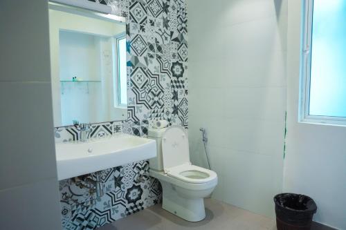 a bathroom with a toilet and a sink and a mirror at Villa Oceana By Heritage in Hikkaduwa