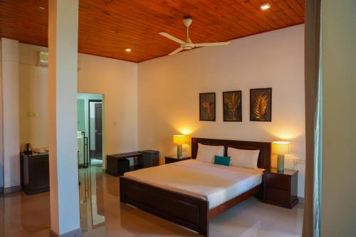 a bedroom with a bed and a ceiling fan at Villa Oceana By Heritage in Hikkaduwa