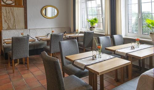 a restaurant with wooden tables and chairs and windows at Hotel Restaurant Bergeshöhe in Mettingen