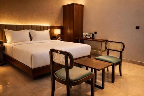 a bedroom with a bed and a table and chairs at Chethan International in Bangalore