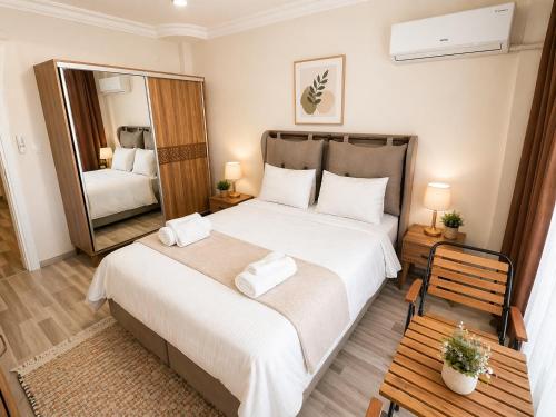 a bedroom with a large bed and a mirror at Begonville Villas Ladies Beach in Kuşadası