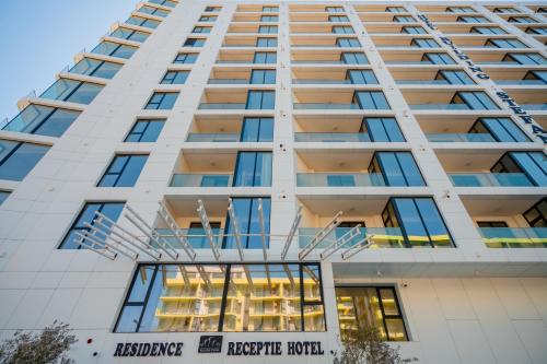 a tall white building with a sign on it at Noble Hotel by Building Stefan in Mamaia Sat/Năvodari