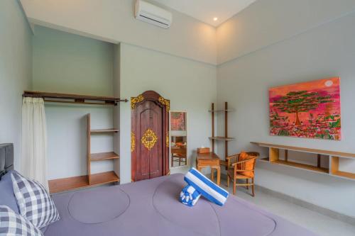 a room with a bed and a table and chairs at Gemello Bali Villa in Keramas