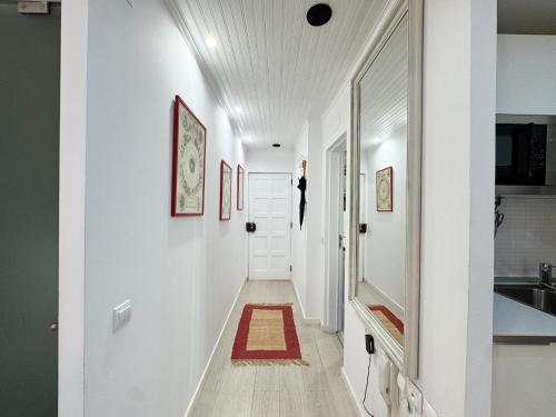a hallway with white walls and a red rug on the floor at Heart of Cascais Cozy 2BR Steps from Beach in Cascais