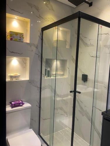 a bathroom with a glass shower and a toilet at Studio Centro Curitiba - para ate 3 pessoad in Curitiba
