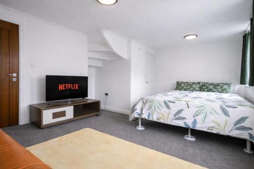 a bedroom with a bed and a tv on a table at Value Stay Comfortable Rooms Windsor Legoland Heathrow in Windsor