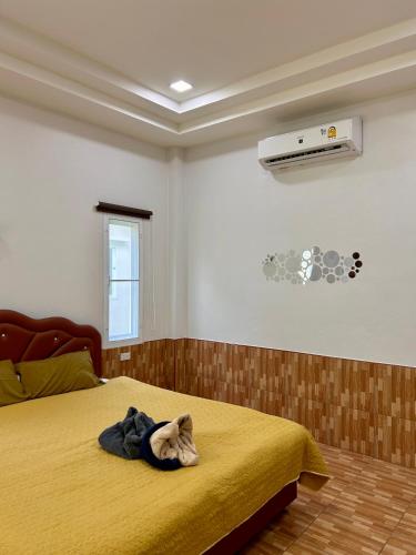 a bedroom with a bed with a yellow blanket at Spacious 1br White House in Ban Nok