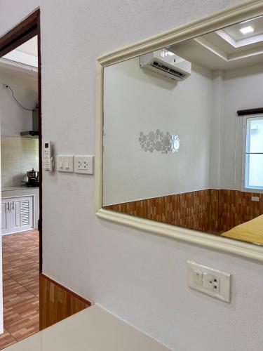 a mirror on a wall in a room at Spacious 1br White House in Ban Nok
