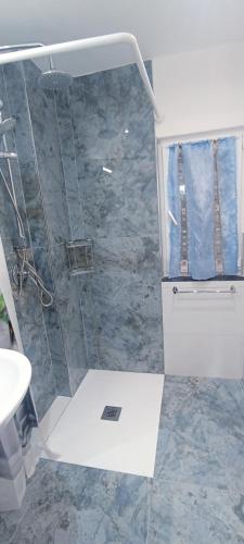 a shower with a glass door in a bathroom at Appartamento Nettuno in Villa Daria a 2 Km dal mare golfo del Tigullio in Chiavari