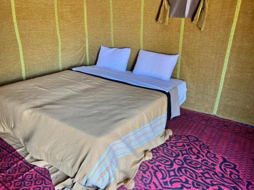 a bed in a corner of a room at Sahara Standard Camp in Merzouga