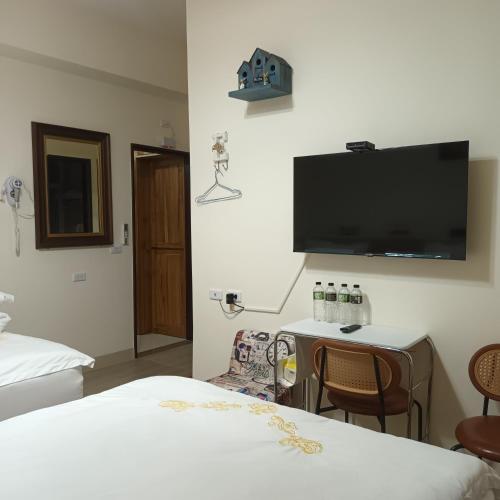 a hotel room with two beds and a tv on the wall at Kiutaro 2 in Yuli