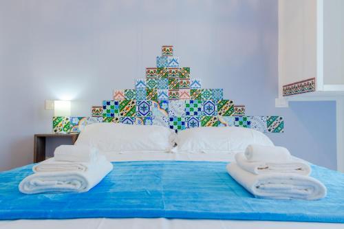 a bed with towels on it with a christmas tree at Sterlizia Rooms in Gallipoli