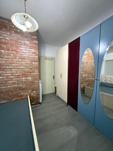 a hallway with a brick wall and a mirror at The Bs Stay in Tirana