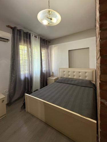 a bedroom with a bed and a large window at The Bs Stay in Tirana