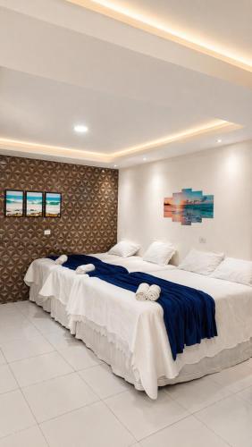 Apartamento Inteligente - 50m da praia في جاباراتينغا: سريران في غرفة فندق مع سريرين