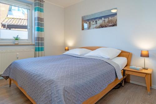 a bedroom with a bed with a blue comforter at Strandlächeln in Neue Tiefe Fehmarn