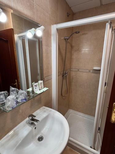 a bathroom with a sink and a shower at Hostal Los Amigos in Olivenza