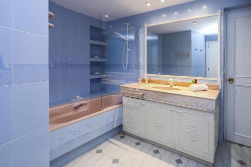 a bathroom with a tub and a sink and a mirror at Spacious Private Villa with Pool in Salou in Salou