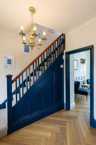 a hallway with a blue door and a stairway at The Kingsway in Ilkley