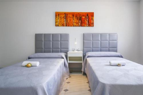 a room with two beds and a painting on the wall at Spacious Private Villa with Pool in Salou in Salou