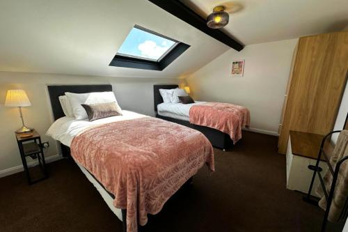 a hotel room with two beds and a window at The Joseph Cosy at Lancaster in Lancaster