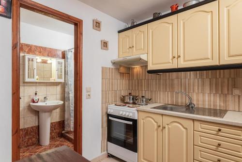 a small kitchen with a sink and a stove at Mulberry Cottage in Samos