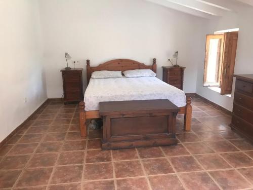 a bedroom with a bed with a wooden frame and a table at Casa Tomas in Albox