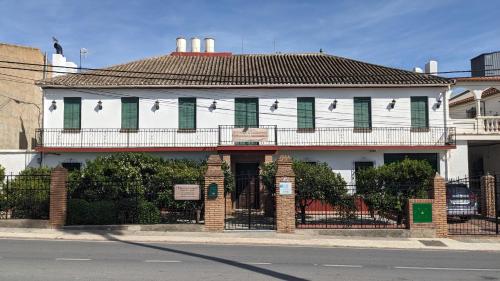 a white building with green shuttered windows on a street at La Cañota King Rooms Adults Only in Talara