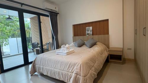 a bedroom with a large bed and a balcony at My Home Villa Phangnga in Phangnga