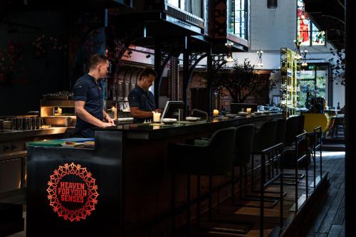 two men standing at a bar in a restaurant at Boutiquehotel The Church in Arnhem