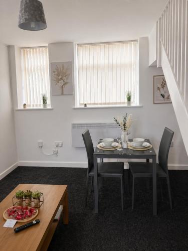a dining room with a table and chairs and windows at Peaceful 1BR Retreat Near Downtown in Manchester