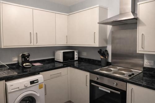 a kitchen with white cabinets and a microwave at Peaceful 1BR Retreat Near Downtown in Manchester
