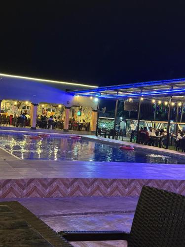 a swimming pool in a hotel at night at Davic-lite hotel and suites in Okitipupa