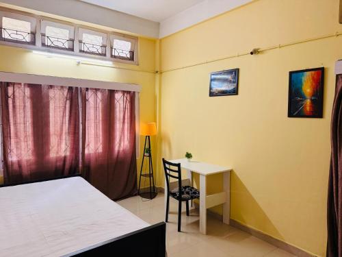 a bedroom with a desk and a bed and a table at Moon Villa Homestay in Nowgong