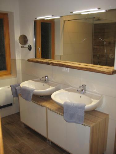 a bathroom with two sinks and a mirror at Ferienwohnung Schachner in Heiligenblut