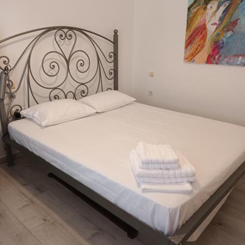 a bed with white towels sitting on top of it at Maria Apostolou villa in Almiros