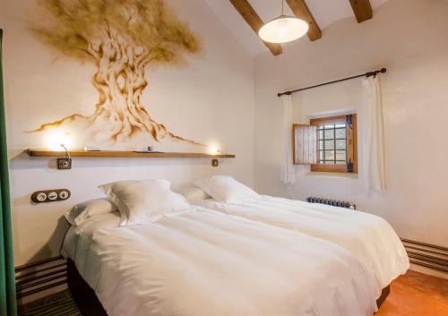 a bedroom with a bed with a tree on the wall at Casa del Labrador in Jumilla