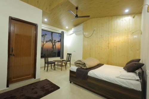 a bedroom with a bed and a table and chairs at Ransuli mountain retreat in Dehradun
