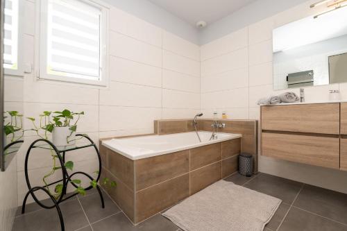 a bathroom with a tub and a sink at Chambre d'hôtes reflets du Golfe in Arradon