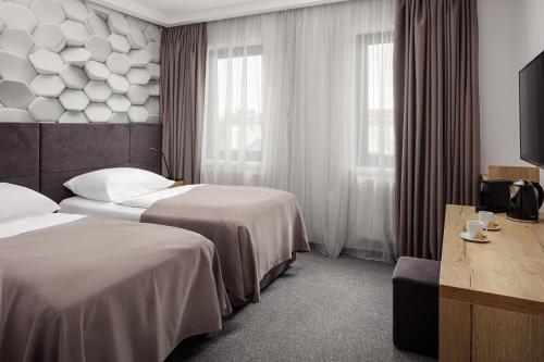 ein Hotelzimmer mit zwei Betten und einem Fernseher in der Unterkunft 4 SMART HOTEL in Olomouc