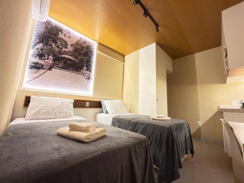 a room with two beds with towels on them at Studios 138 in Belém