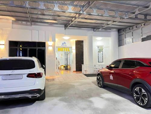 two cars parked in front of a garage at Cảnh Việt Hotel in Tây Ninh