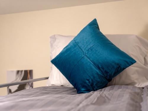 a blue pillow sitting on top of a bed at Premium 2BR Retreat for Long Stays in Manchester