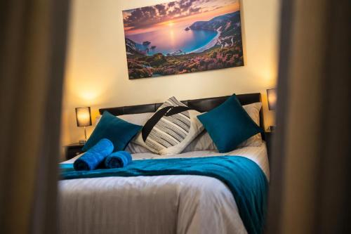 a bedroom with a large bed with blue pillows at Premium 2BR Retreat for Long Stays in Manchester